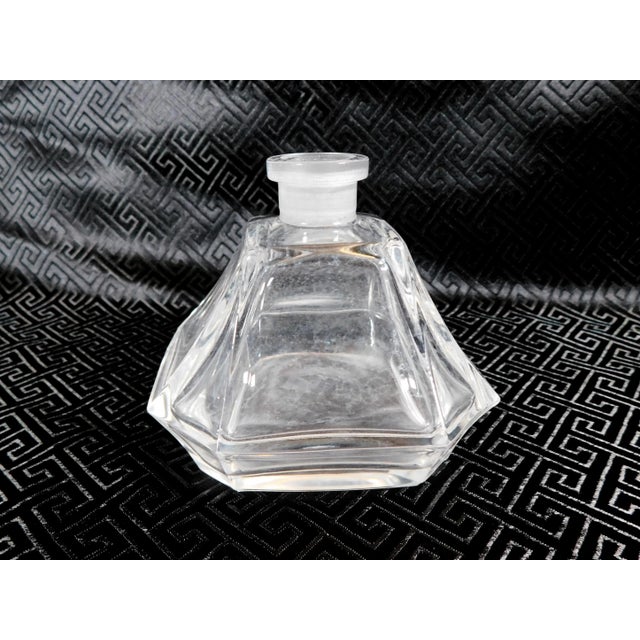 This is a square base, clear glass, perfume bottle with a tapered stopper that fits well, but may not be original to the...