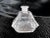 This is a square base, clear glass, perfume bottle with a tapered stopper that fits well, but may not be original to the...