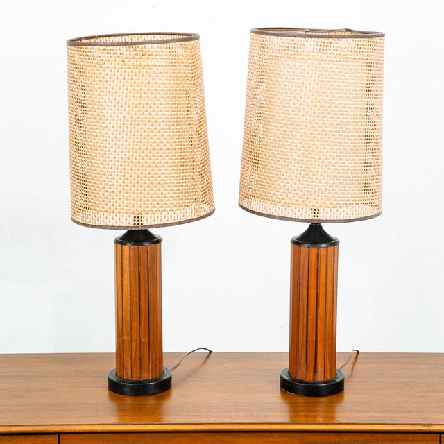 Compact mid century American round solid walnut lamp set with unique cane shades. Both are fully functional and are in...
