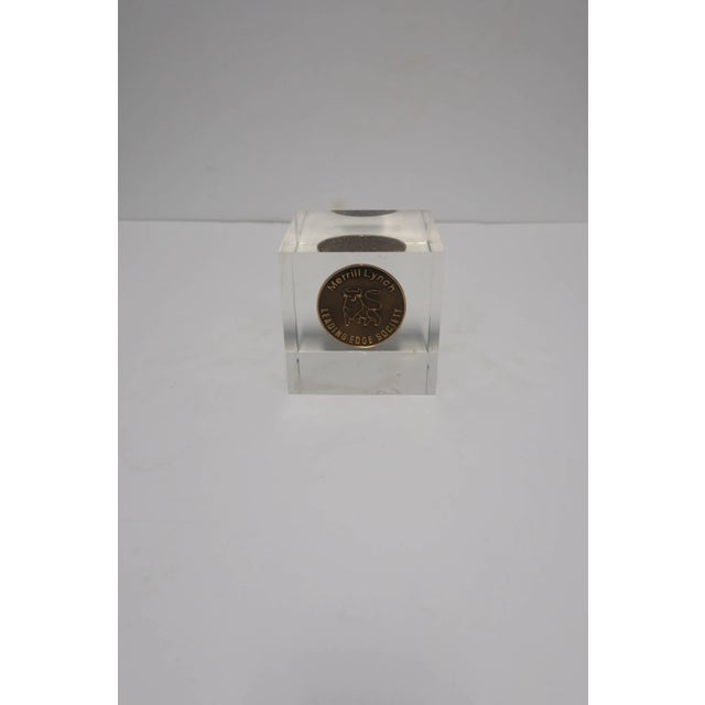 A 4" Lucite square with inset gold coin; an award cube from Merrill Lynch. Lucite holds internal coin with iconic 'Merrill...