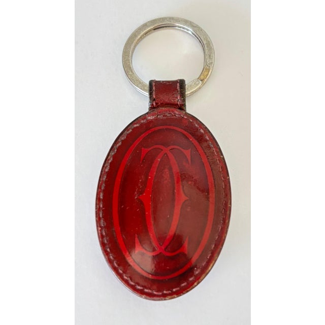 Must de Cartier Burgundy Leather Key Chain with Double C Motif, Circa 1980s An elegant and highly collectible key chain...