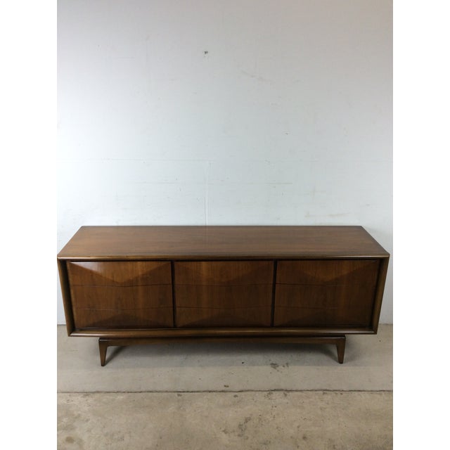 This mid century modern lowboy dresser by United Furniture Co. features hardwood construction, original walnut finish,...