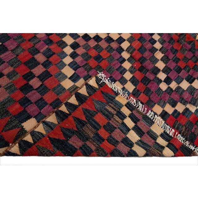 Beautiful kilim handmade wool runner with a purple field. This Vintage flatweave rug has red, beige, gray, and navy blue...