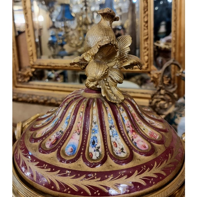 This elegant French-style porcelain covered vase features a rich burgundy finish accented with intricate gold leaf...