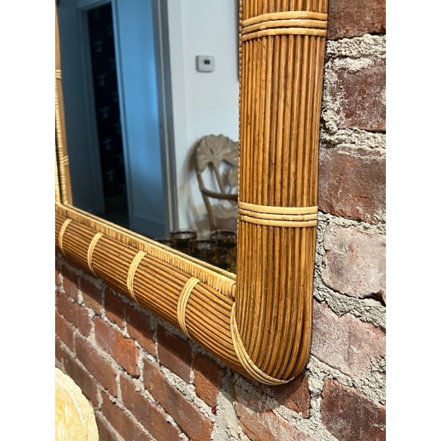 A soft arch and natural rattan frame give this vintage mirror its easy, coastal charm. Hand-wrapped reed bindings trace...