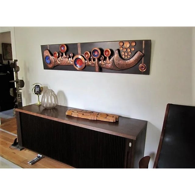 Handmade wall sculpture of hammered copper. Plastically elaborated forms. Patinated with linear etchings in colored enamel.