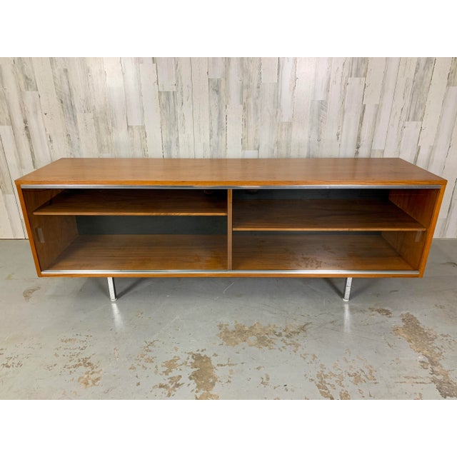 Rare Glass sliding doors on a walnut display cabinet with adjustable shelves. Chrome legs with original Domes of silence...