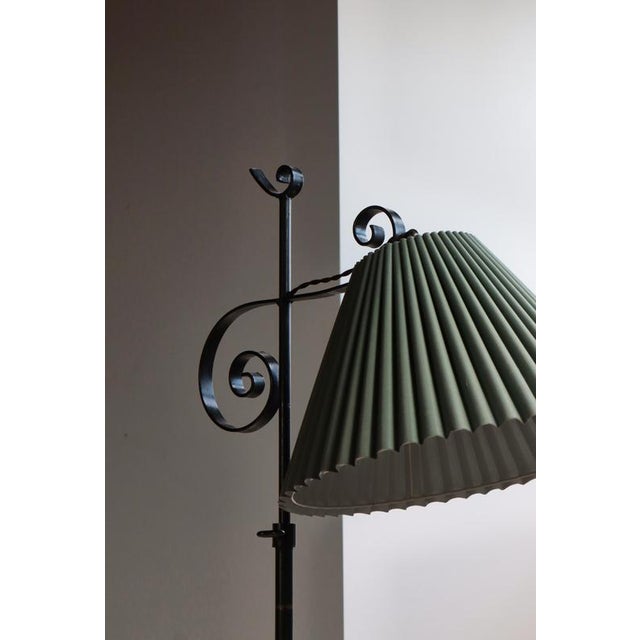 Elegant Scandinavian Art Deco floor lamp from the 1930s, handcrafted in wrought iron with graceful scrollwork details and...