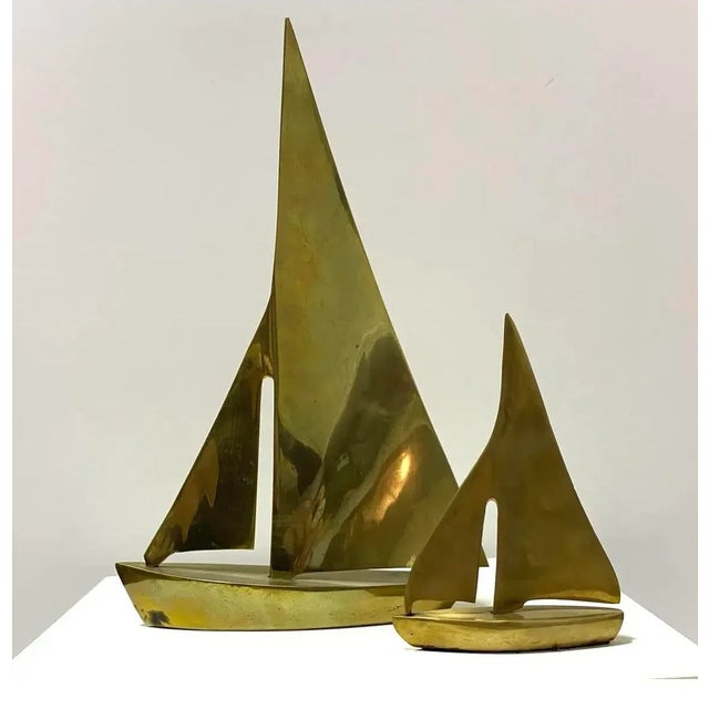 A graduated pair of vintage brass sailboat sculptures featuring simplified geometric sails and gently curved hulls. Their...