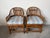 A charming pair of vintage Brighton Pavilion style bamboo and rattan chairs featuring gracefully curved barrel backs and a...