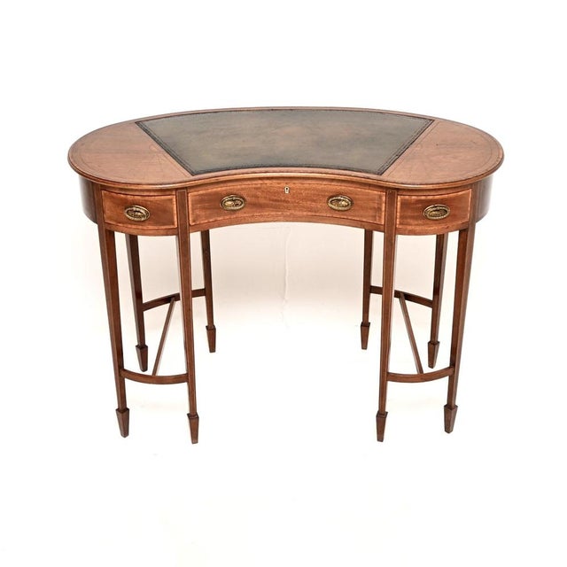 A beautiful and elegant antique Edwardian inlaid kidney shaped desk. This was made in England, it dates from the 1900-1910...