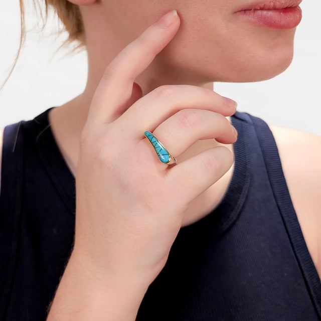 A fine vintage gold and turquoise ring. In 14 karat yellow gold. With a bezel-set turquoise cabochon with gold accent...