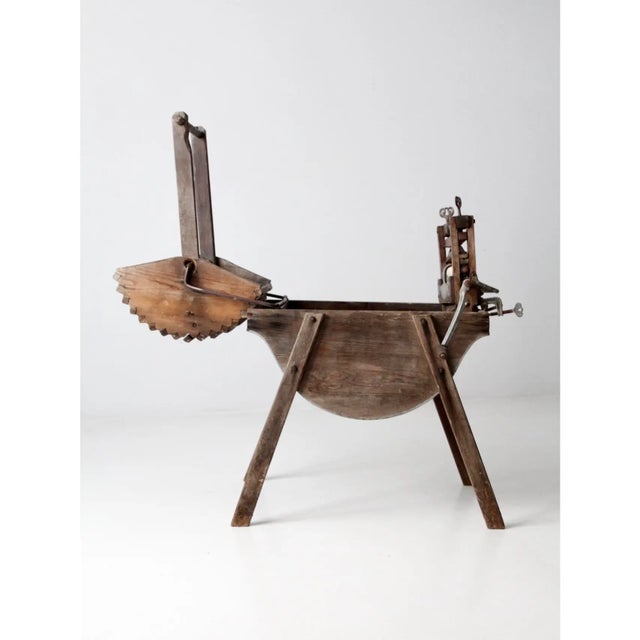 An antique washing machine dating to the late 19th century, featuring a sturdy wooden frame wash stand fitted with a...