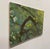 In "Komorebi," intricate layers of green and brown capture the interplay of light filtering through a canopy of leaves,...