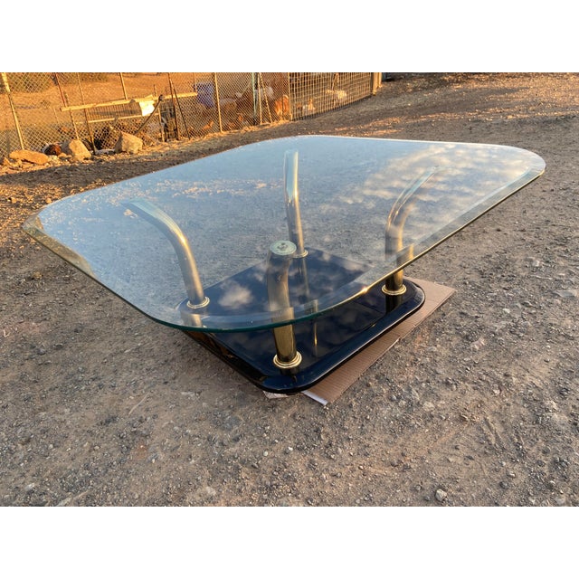 This vintage postmodern Karl Springer style brass tusks coffee table features a square shape with gold color and beveled...