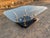 This vintage postmodern Karl Springer style brass tusks coffee table features a square shape with gold color and beveled...