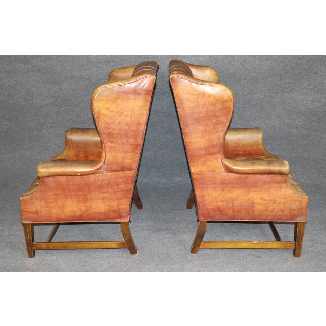 This handsome pair of English-made mahogany-framed leather wingback armchairs, dating to approximately the 1960s, offers...