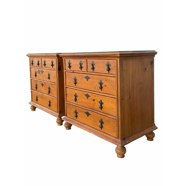 A pair of solid pine chests of drawers by The Milling Road Division of Baker Furniture. Each dresser has five dovetail...