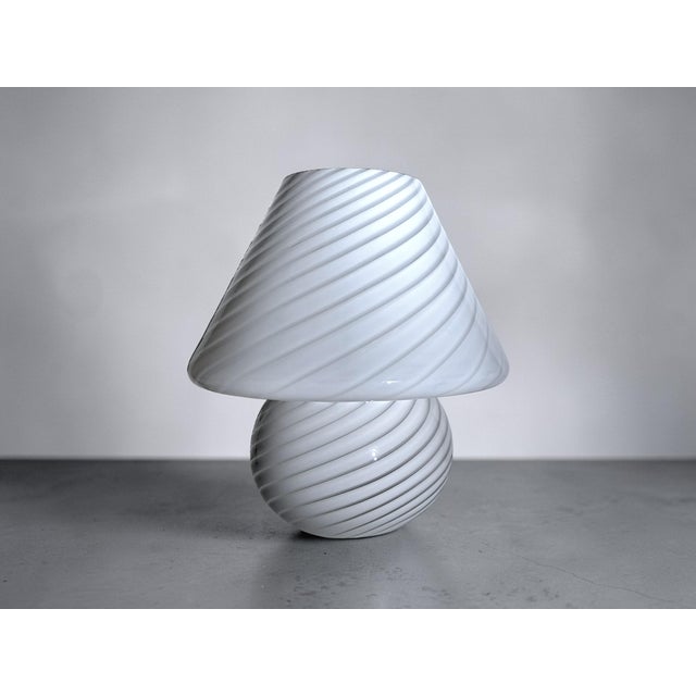 Large mushroom lamp in opal white glass with an elegant mushroom swirl decoration, Murano, 1970s. This table lamp embodies...