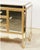 A glamorous Hollywood Regency-style sideboard enveloped in beveled mirrored-glass panels and framed in a warm antiqued-...