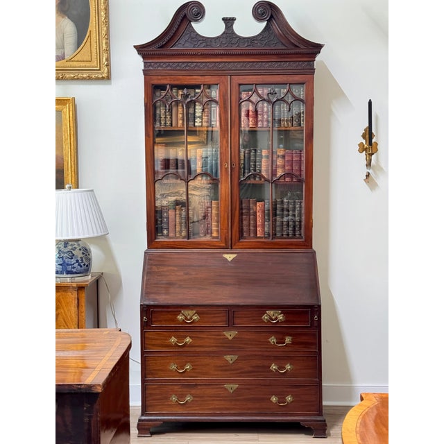 An early George III period mahogany bureau bookcase, the swan neck pediment with carved rosette terminals and a blind-...