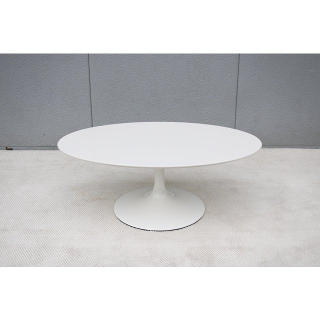 Fabulous 42" oval white coffee table with white tulip pedestal base in the style of Eero Saarinen. The Saarinen tulip...