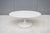 Fabulous 42" oval white coffee table with white tulip pedestal base in the style of Eero Saarinen. The Saarinen tulip...