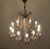 Large 12-light chandelier with a gilded iron frame and warmly colored blown glass pendants. The lamp's design and...
