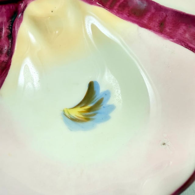 A French porcelain oyster plate, circa 1890 – 1910. Six shell shaped oyster wells with multicolored, hand painted ‘eyes’...