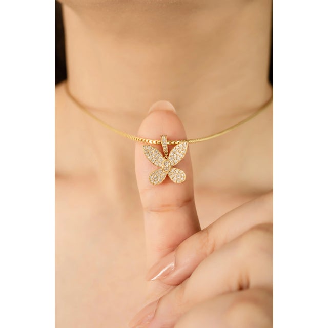 This butterfly pendant is beautifully crafted in 14k yellow gold and accented with 0.49 carats of round brilliant-cut...