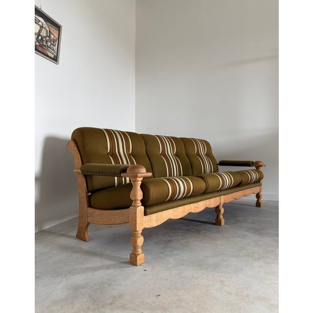 Danish oak sofa in the original striped wool upholstery. In the style of Henning Kjærnulf and bearing some resemblance to...