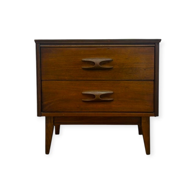 This vintage mid-century modern nightstand features a rich warm walnut wood finish with prominent natural graining on the...