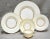 A 1950s graceful Minton bone china dinner service having a soft cream outer bands that have a swirling concave flutes,...