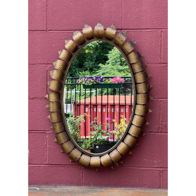 This lovely Spanish mid-century oval sunburst mirror features curved radiating leaves surrounding a frame with a delicate...