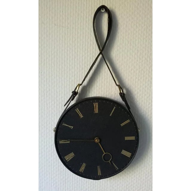Decorative wall clock in leather in the style of Jacques Adnet. Original clockwork has been replaced (see photo). The...