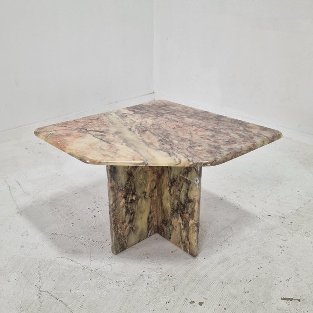 This elegant sculptural side table is crafted entirely from solid marble and originates from Italy. The table features a...