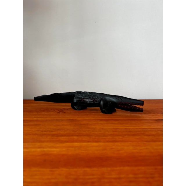 Hand-carved from a single piece of wood and painted in black and red by Brazilian indigenous artisans. Possibly a letter...