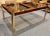 A striking 1970s dining table by Century Furniture, featuring richly figured burl wood paired with sleek brass legs for a...