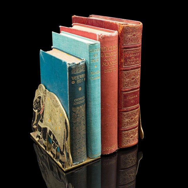 This is a fine pair of antique elephant bookends. An Indian, etched brass decorative book rest, dating to the late...