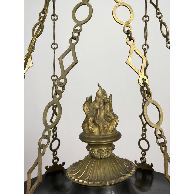 An Empire-style, black and gold chandelier made in Sweden circa 1830. In a bowl-form with 5 candle-style lights with...