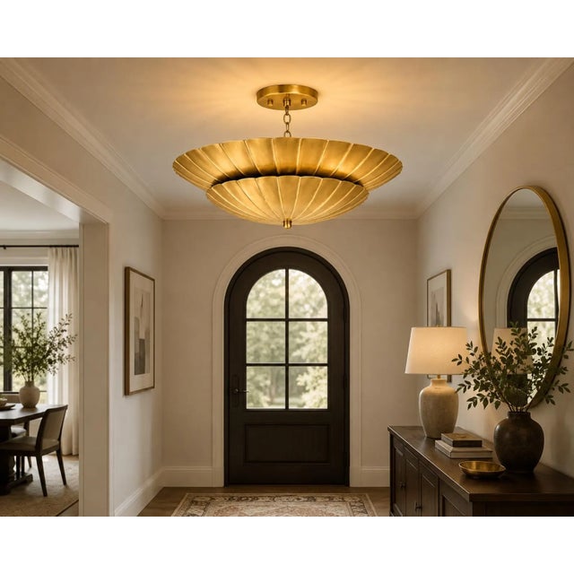 Crafted from solid brass, this handcrafted chandelier features two layered scalloped shades inspired by the graceful form...