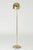 Brass floor lamp from Bergboms, with a sleek, rounded design topped off with a little tip at the top of the lampshade....