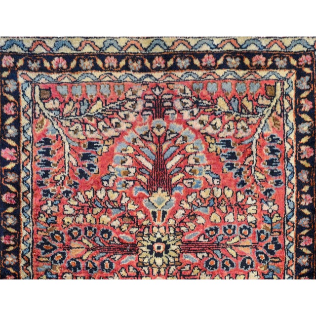 A wonderful early 20th century petite Persian Sarouk rug with a large-scale mirrored floral pattern woven in light and...
