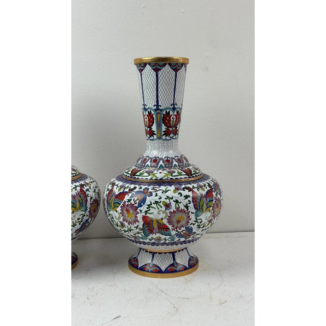 Pair of Chinese cloisonne vases of bulbous form with long necks, decorated with multicolored lotus and foliate designs on...