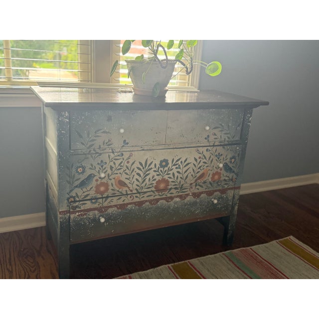 A charming hand-painted folk art chest of drawers inspired by traditional Swedish decorative painting. Featuring a...