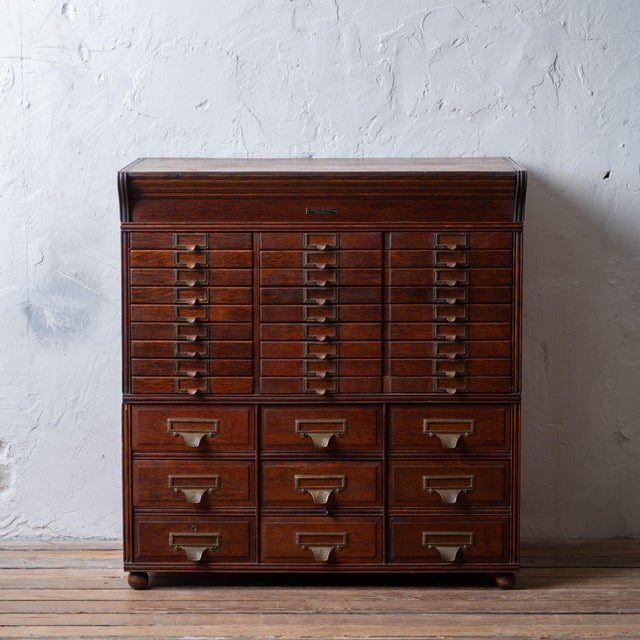 A Yawman & Erbe oak modular file cabinet, circa 1910. Three parts; top section with smaller drawers on left and larger...