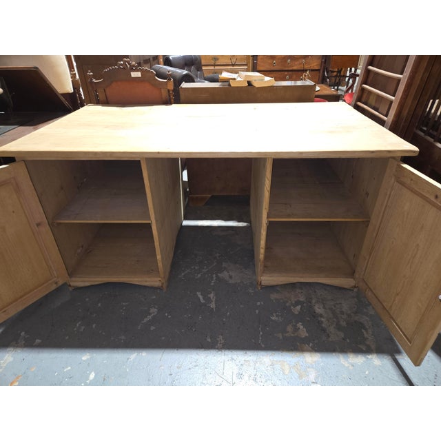 A substantial German pine partner's desk featuring a thick plank top resting on twin cupboard pedestals. Crafted from...