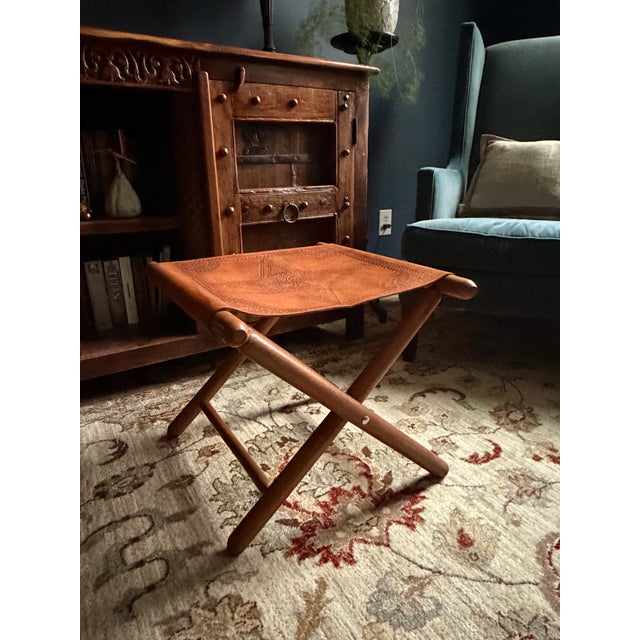 Rustic vintage leather tooled stool. Conveniently folds up for easy storage and portability. Lovely symmetrical pattern...