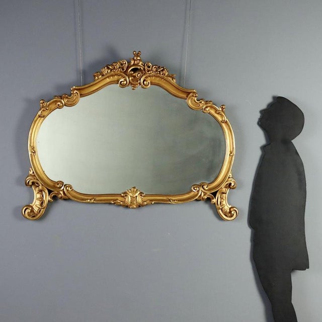 Carved and gilded wooden table mirror, crafted in Italy in the early 20th century. The richly openwork frame is adorned...