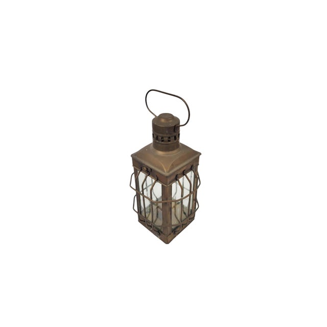 This vintage brass lantern, designed to hold a candle or small oil lamp, blends historical function with timeless...